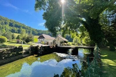 Petit pont traversant ruisseau en paysage champêtre vert