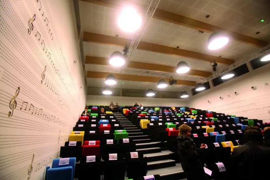 Salle de spectacle avec sièges colorés et décor musical
